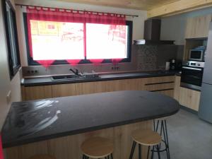 a kitchen with a black counter top and a window at Chalet des Lys - tout confort - 12 personnes in Valloire