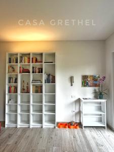 a room with white book shelves and a desk at Appartamento Grethel - Rebomaholidays in Gardone Riviera