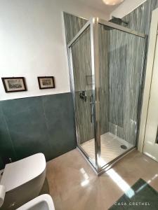a shower stall in a bathroom with a toilet at Appartamento Grethel - Rebomaholidays in Gardone Riviera