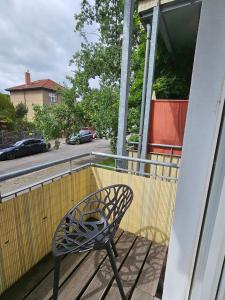 a metal chair sitting on a porch next to a building at Casa Frida - Business flat near BER, kitchen, bathroom, balcony, workspace, 24" Monitor, Wifi, SmartTV, Netflix, car park in Berlin
