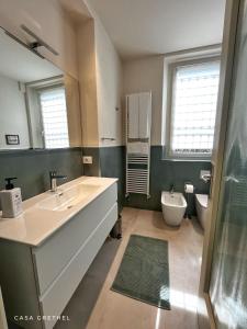 a bathroom with a large sink and a toilet at Appartamento Grethel - Rebomaholidays in Gardone Riviera