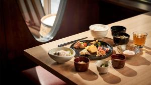 Daiwa Roynet Hotel Morioka في موريوكا: طاولة عليها صحن من الطعام والأطباق
