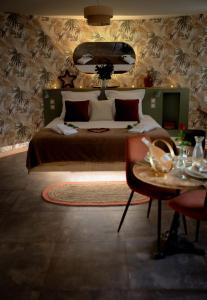 una camera con un grande letto e un tavolo di Le Mas aux Amoureux , Suite Romantique et Spa a Le Barcarès