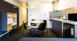 a kitchen with a table and chairs in a kitchen at Jeju Bricks Hotel in Seogwipo