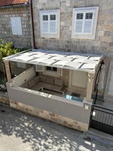 a dog house with a roof on the side of a building at @trstenik in Trstenik