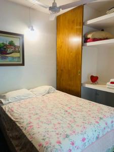 1 dormitorio con 1 cama con colcha de flores en Casa cerca del microcentro y costanera en Posadas