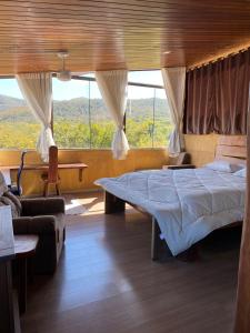 a bedroom with a bed and a large window at Santuário na Chapad a dos Veadeiros in Alto Paraíso de Goiás