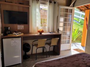 a home office with a desk and two chairs at Pousada Recanto João de Barro in Cunha