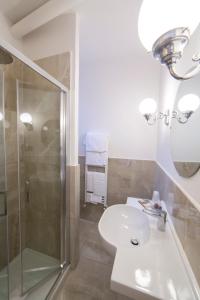 a white bathroom with a shower and a sink at Hotel Fortuna in Perugia