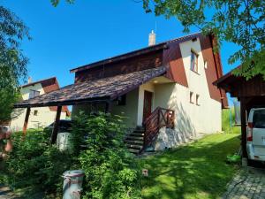 a house with a porch and stairs in front of it at Trnka in Liptovský Trnovec