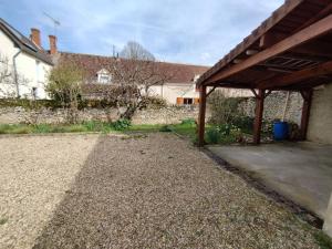 un edificio con una zona cubierta junto a un patio en Maison de campagne proche Beauval, en Selles-sur-Cher 4 fotos más