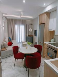Il dispose d'une cuisine et d'un salon avec une table et des chaises rouges. dans l'établissement LUXE Boutique With Balcony, à Thessalonique