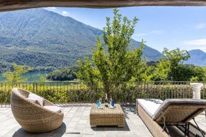 een patio met 2 stoelen en een tafel met uitzicht op een berg bij Stunning Estate on Como lake, Free parking & Wi-fi in Carlazzo