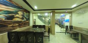 a dining room with a large painting on the wall at KINGSWAY HOTEL AND RESTAURANT Ajmer Dargah 350 Meter in Ajmer