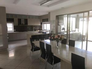 a kitchen with a table with chairs and a vase of flowers at 6 rooms villa in Deer Park