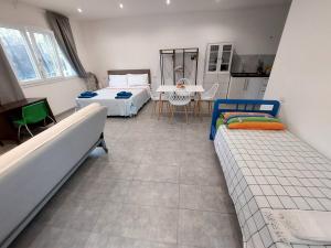 a room with two beds and a table and a kitchen at Oasi Santaquilina in Rimini