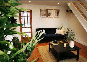 a living room with a black couch and a table at The Ridings in Dundry