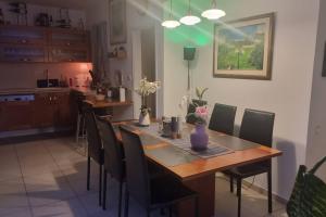 uma sala de jantar com uma mesa de madeira e cadeiras em Home way from home em Netanya