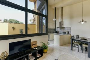 a kitchen with a large tv and a dining room at L'Heura, Casa terrassa Empordà Banyoles in Navata