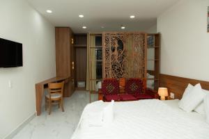 a hotel room with a bed and a desk and chair at Thiên Tài Hotel in Ho Chi Minh City +46 photos