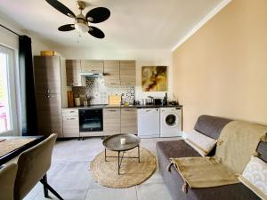 sala de estar con sofá, mesa y cocina en Tiny Harmony - Logement confortable avec jardin et jacuzzi privés près d’Aix en Provence, en Venelles