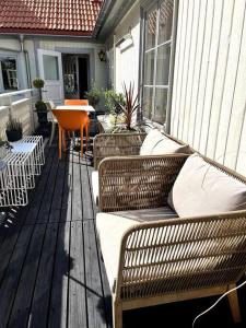 eine Veranda mit Korbstühlen und einem Tisch auf einem Haus in der Unterkunft Gränna Grandeur Stay in Style in Gränna