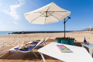 una mesa y una silla con sombrilla en la playa en Terrazza Sul Mare, en Trappeto