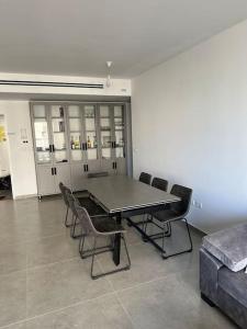 une salle de conférence avec une table, des chaises et un canapé dans l'établissement Appartement Guivat Olga 4 pièces proche mer, à Hadera