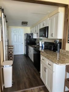 a kitchen with white cabinets and black appliances at Ocean Dream Vacation in Myrtle Beach