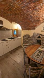 een keuken met een tafel en een stenen muur bij Maison du Pont Romain in Aosta