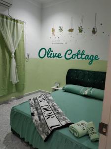 a room with a bed with a wine exchange sign on the wall at Olive Cottage in Kampong Ru Lima