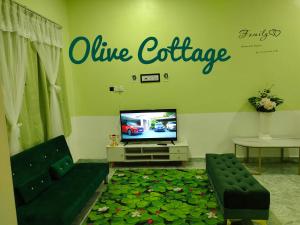 a living room with a tv and a living room with leaves on the floor at Olive Cottage in Kampong Ru Lima