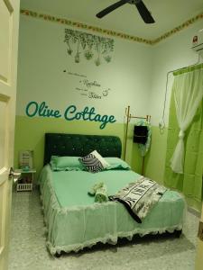a bedroom with a bed with a sign on the wall at Olive Cottage in Kampong Ru Lima