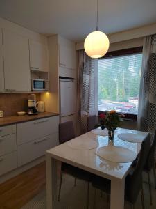 eine Küche mit einem Tisch und einer Blumenvase darauf in der Unterkunft City Apartment Tieva in Rovaniemi