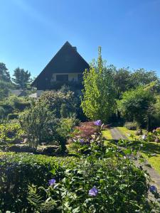 un jardín con flores y una casa de fondo en Ferienwohnung Familie Petschel, en Kurort Jonsdorf