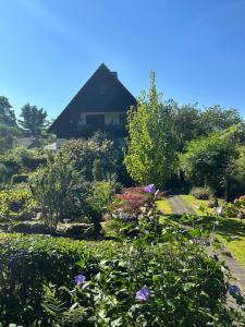 a garden with flowers and a house in the background at Ferienwohnung Familie Petschel in Kurort Jonsdorf