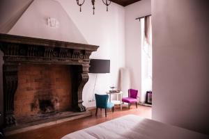 - une chambre avec une cheminée, deux chaises et un lit dans l'établissement Flowers Apartments, à Rome
