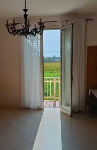 a room with a chandelier and a door with a view at VersoSUD in Marsala