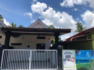 a house with a gate and a sign in front of it at Abe.Cottage 2 in Kampung Kuala Besut