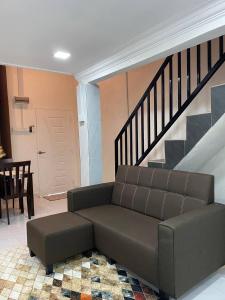 a living room with a couch and a staircase at Abe.Cottage 2 in Kuala Besut