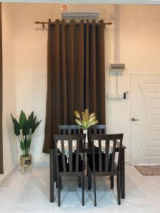 a table and chairs in a room with a curtain at Abe.Cottage 2 in Kuala Besut