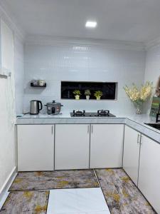 a kitchen with white cabinets and a counter top at Abe.Cottage 2 in Kuala Besut