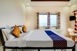 een slaapkamer met een groot bed en een raam bij Shinde Niwas Mahableshwar in Mahabaleshwar