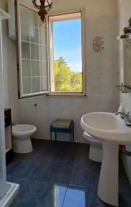 a bathroom with a sink and a toilet and a window at VersoSUD in Marsala