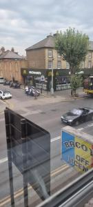 uma vista de uma janela de uma rua com um carro em Cricklewood Broadway Guest Home em Londres