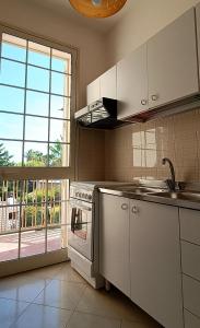 a kitchen with white appliances and a large window at VersoSUD in Marsala