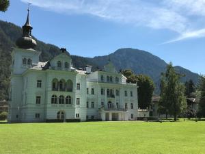a large white house with a grass field in front at Chalet Grubhof in Sankt Martin bei Lofer