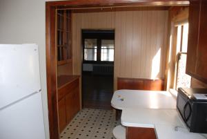 eine Küche mit einem Kühlschrank und einem Tisch darin in der Unterkunft Beach Lovers Delight cottage in North Camellia Acres