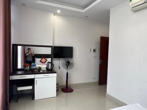 a room with a desk with a mirror and a fan at Hotel Liberty Violet in Phúc Yên