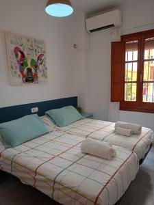 a large bed in a room with two towels on it at Apartamento Dueñas in Seville